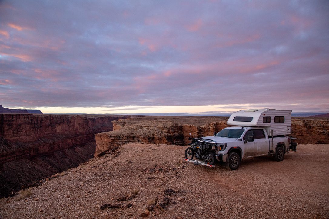 The Pilgrim camper parked at a canyon overlook at sunset with bikes loaded